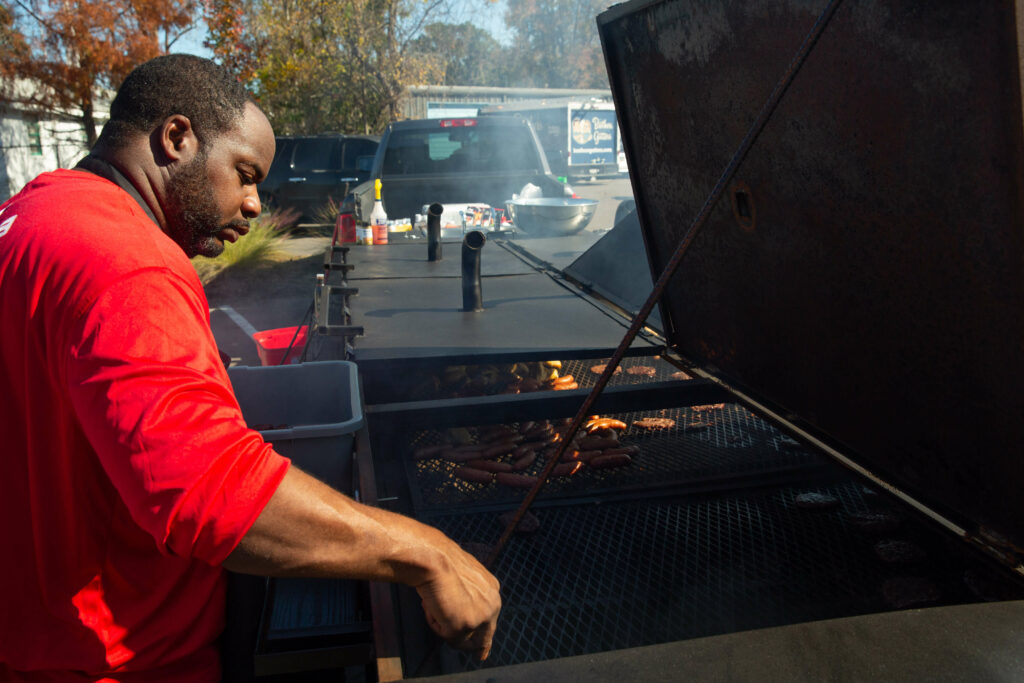 A South Carolina grill master grilling food on a charcoal grill.